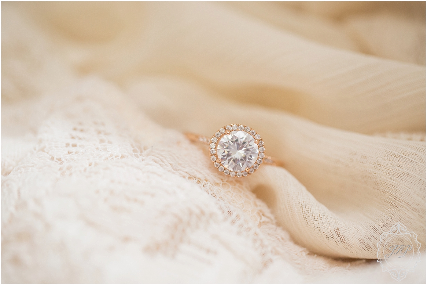 A large rose gold engagement ring sits on a piece of ivory lace in Columbia, South Carolina.
